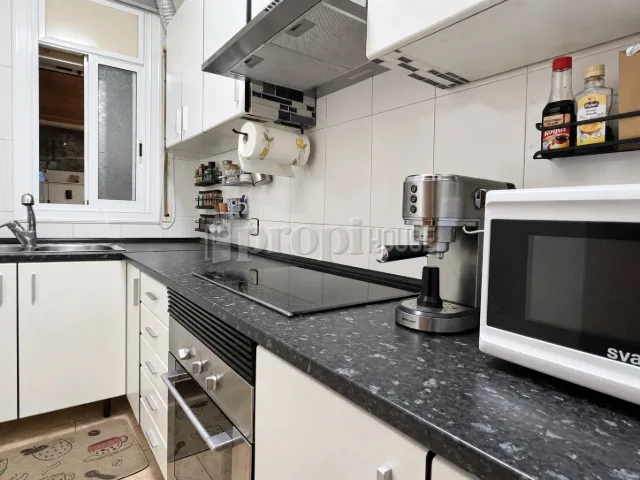 La cocina desde el otro extremo, con la placa de inducción y el horno