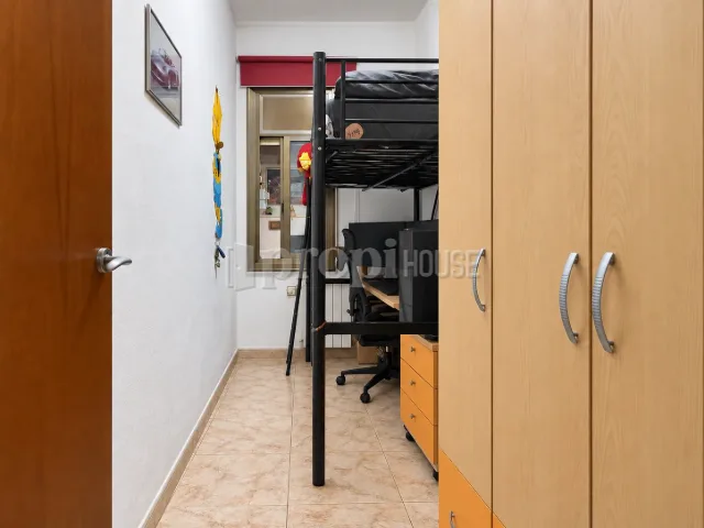 Habitación individual con cama alta, escritorio y armario