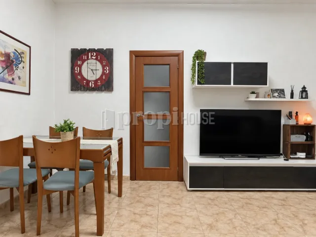 La zona de comedor, con el mueble de televisión a la derecha