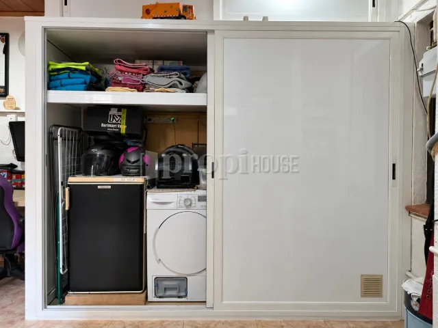 El armario de la galería abierto: lavadora, secadora y sitio de sobra