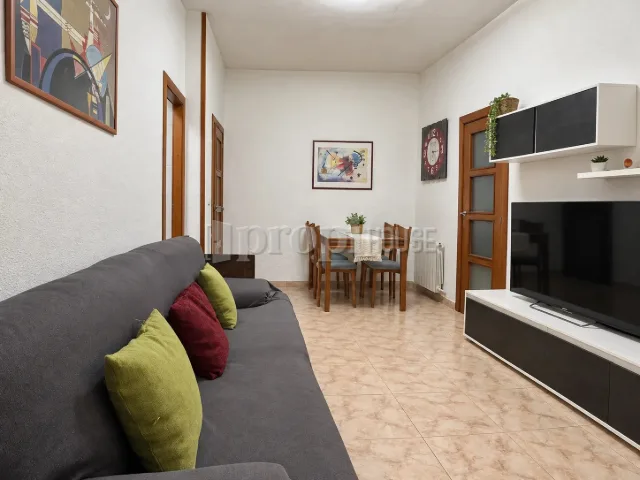 El salón-comedor entero desde el sofá, con la mesa al fondo
