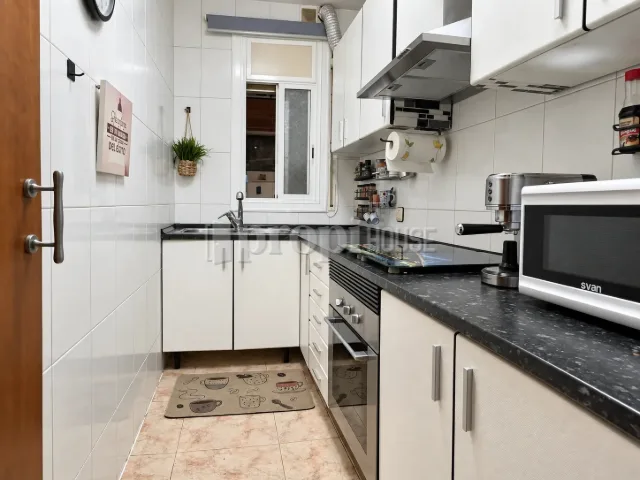 Cocina independiente con encimera de granito, muebles blancos y ventana