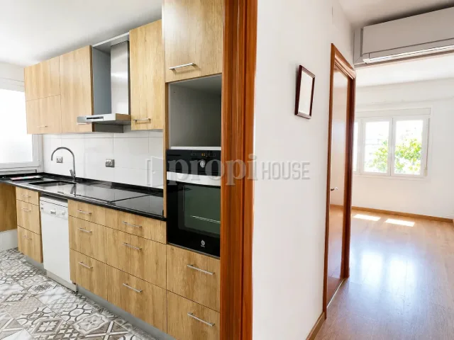 Cocina con horno y lavavajillas, y el paso hacia el resto de la vivienda