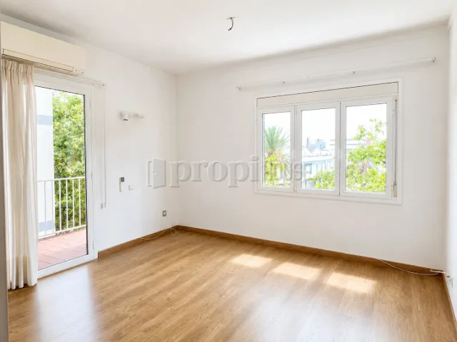 Estancia exterior con salida al balcón y ventana a la avenida