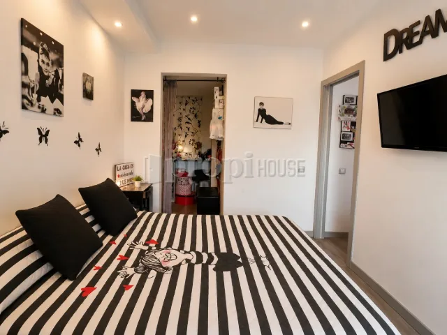 Habitación principal con cama doble y paso al vestidor