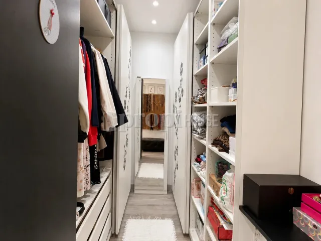 Vestidor con estanterías y barras a ambos lados