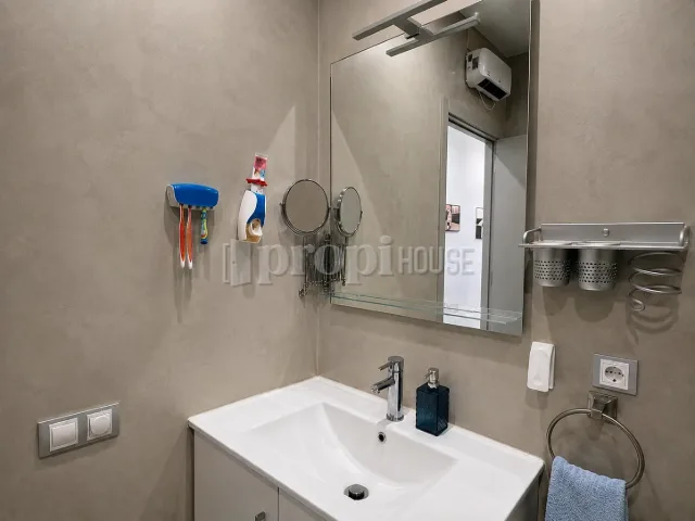 Lavabo del baño con espejo y ventana