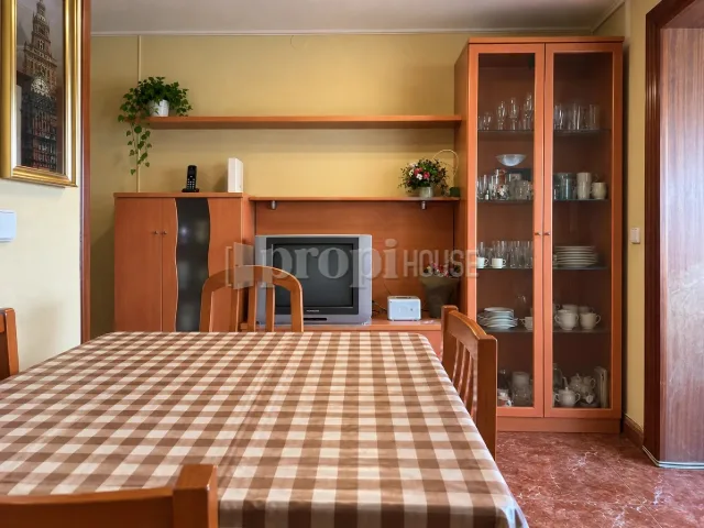 Salón-comedor con mesa, mueble y vitrina