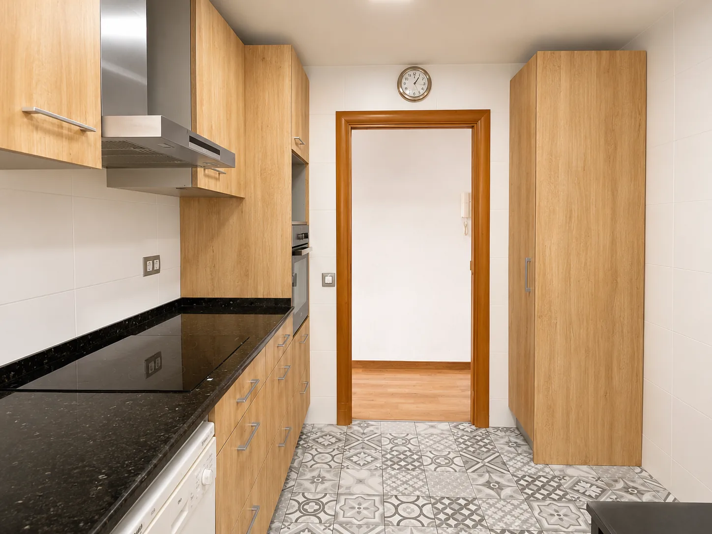 Cocina office con encimera de granito, inducción y columna de armarios