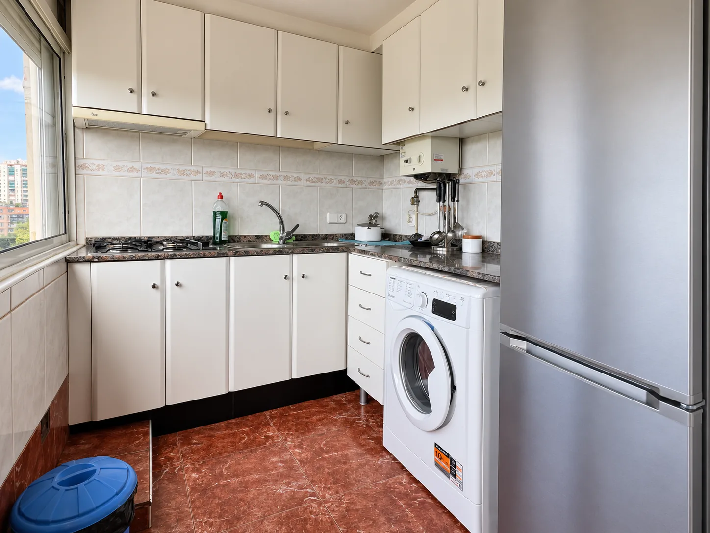 Frente de la cocina con fregadero, lavadora y nevera