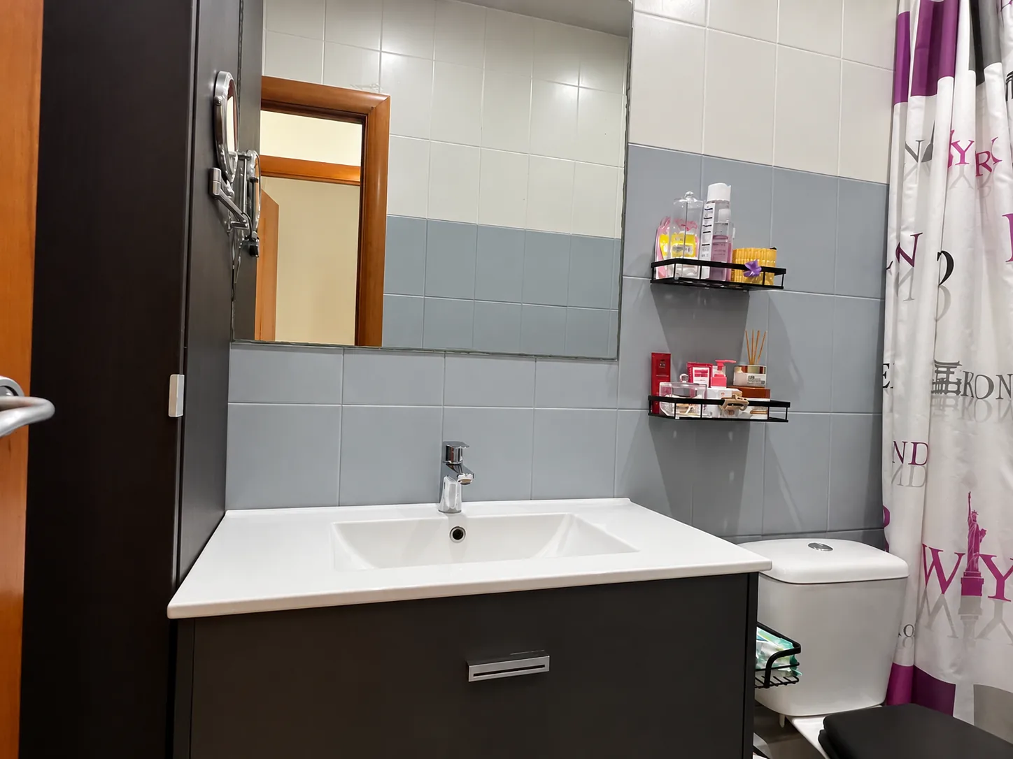Baño con mueble de lavabo, espejo grande y alicatado en dos tonos