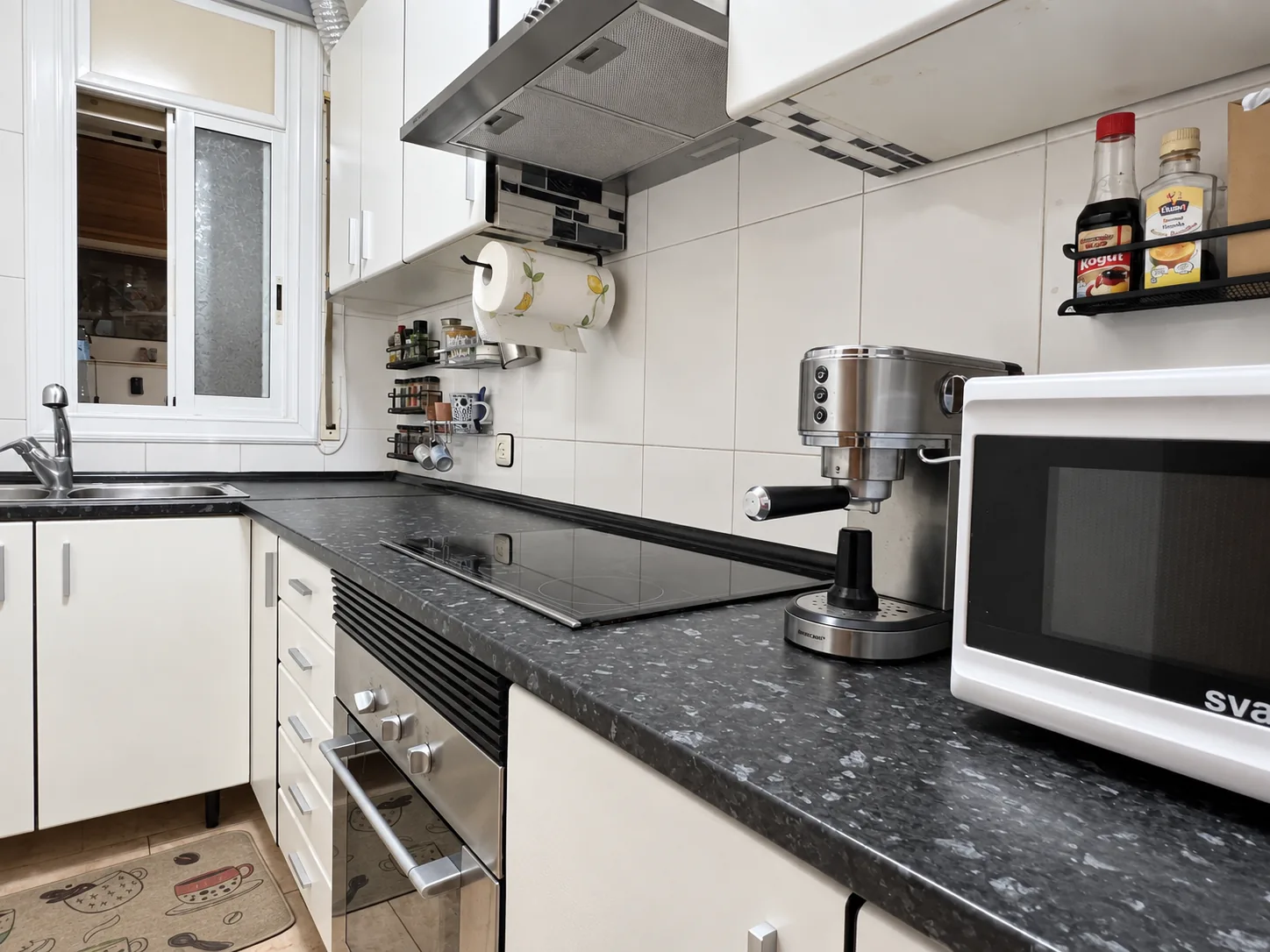 La cocina desde el otro extremo, con la placa de inducción y el horno
