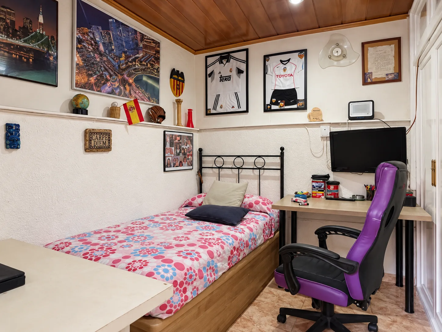 La habitación del techo de madera, con la cama y el escritorio