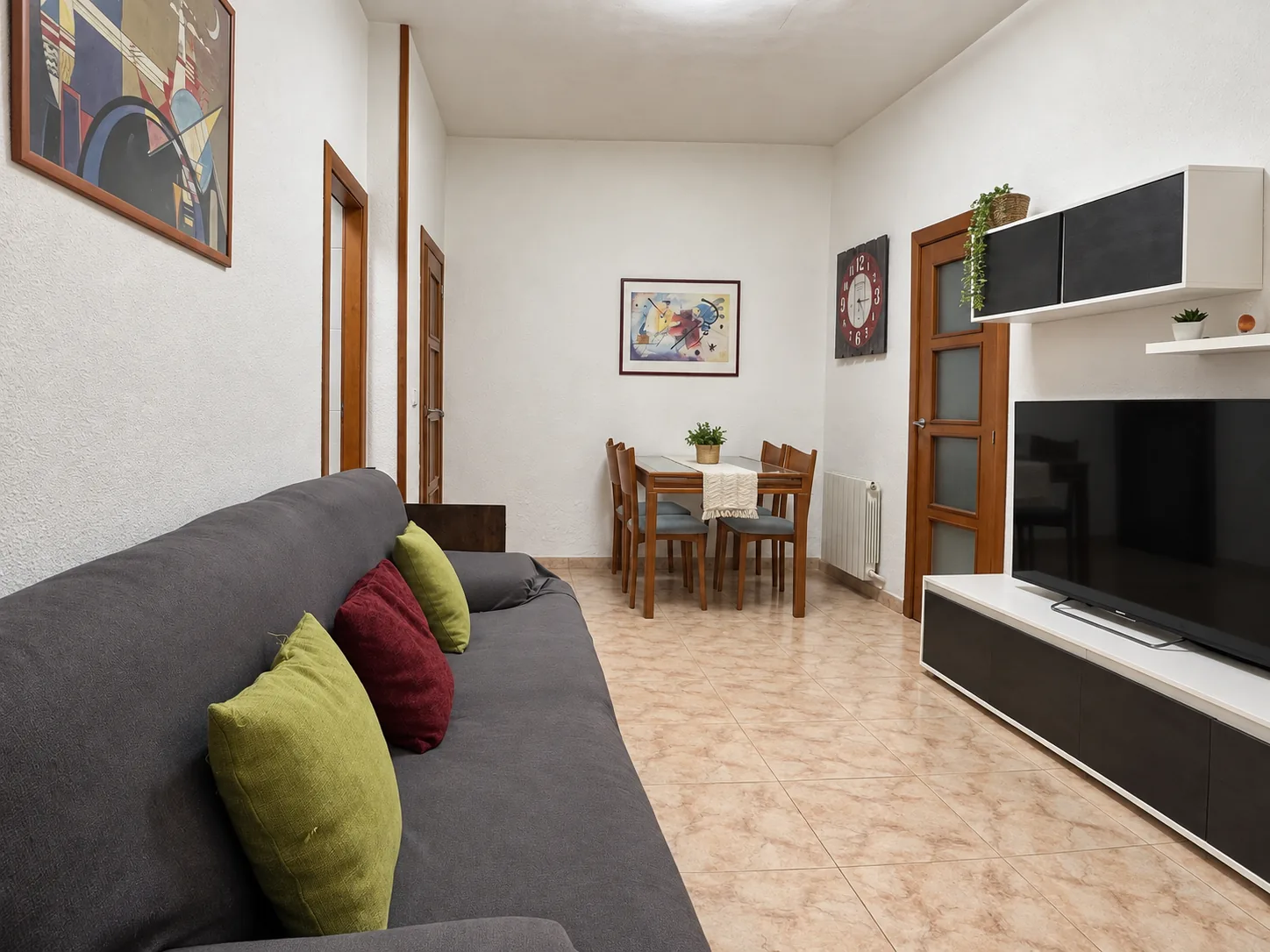 El salón-comedor entero desde el sofá, con la mesa al fondo